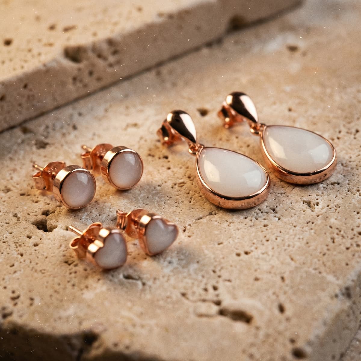 Rose gold and milky white resin keepsake earrings displayed on a stone surface, made with a breastmilk earrings diy kit