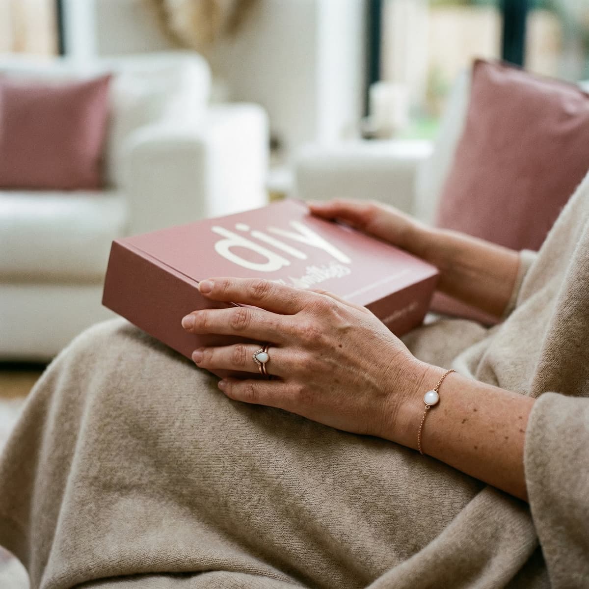 Mother holding a DIY by MILKIES box at home, showing why an at-home breastmilk jewelry resin kit is an easy, private way to create a meaningful keepsake.