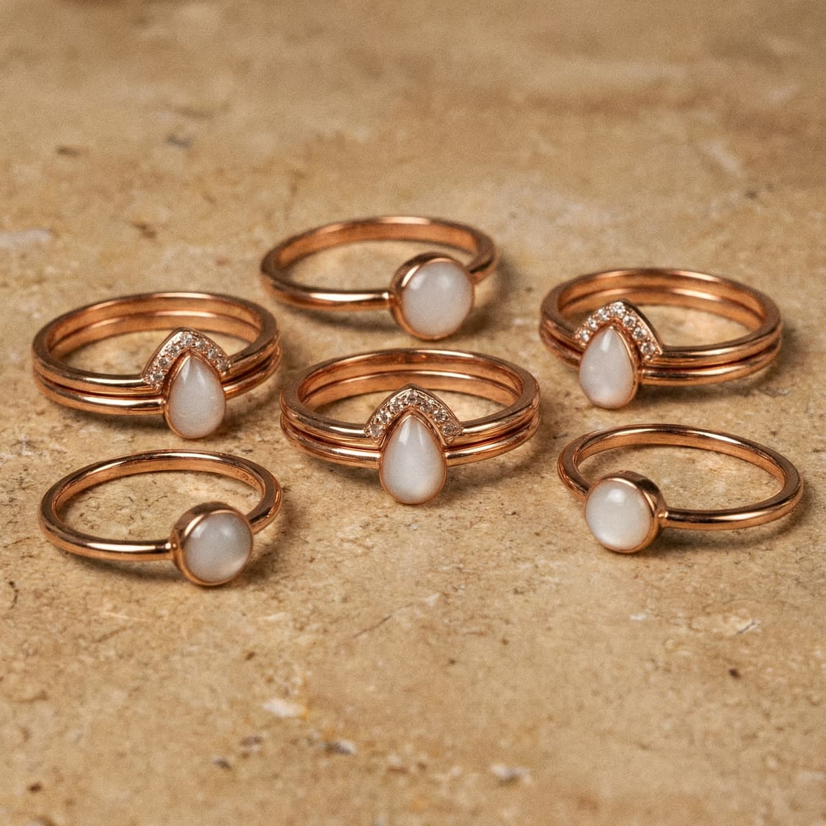 Rose-gold rings with milky white resin stones in round and teardrop shapes, showing results you can create with a breastmilk ring making kit at home.