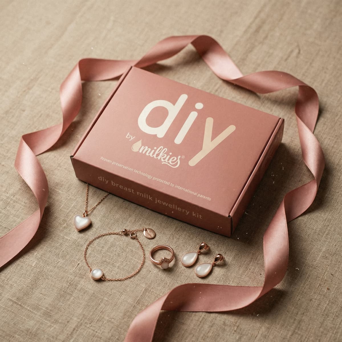 Pink DIY by MILKIES breast milk jewellery kit gift for new mom, presented in a ribboned box with matching necklace, bracelet, ring and earrings to create a keepsake at home.