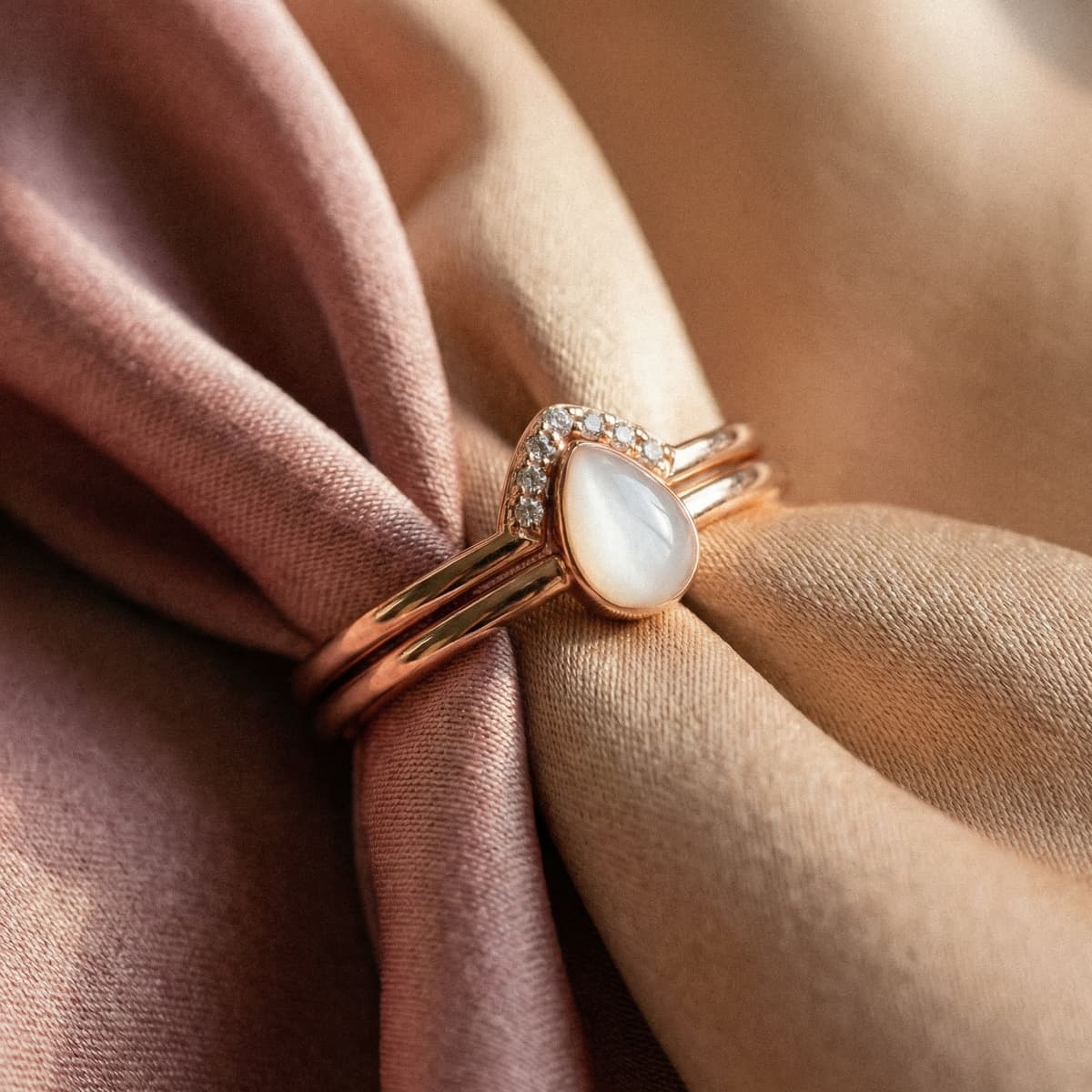 Rose gold ring featuring a pear-shaped milky resin stone and tiny crystals on blush satin, a delicate motherhood keepsake jewelry piece