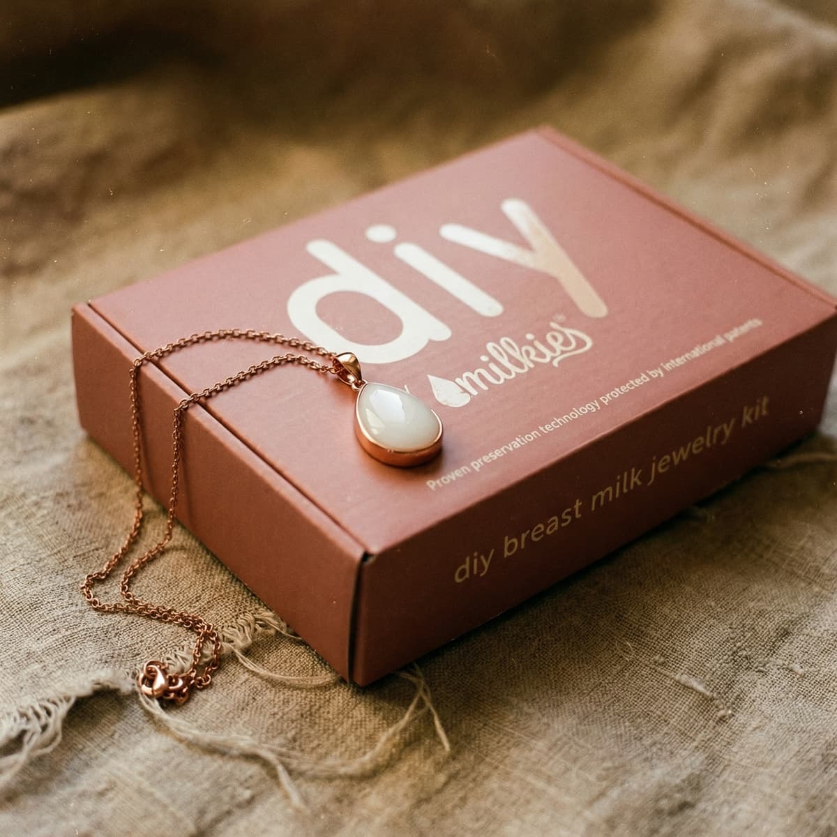 Elegant DIY by MILKIES breast milk jewelry kit box with rose-gold pendant necklace on linen background, ideal for unique push presents