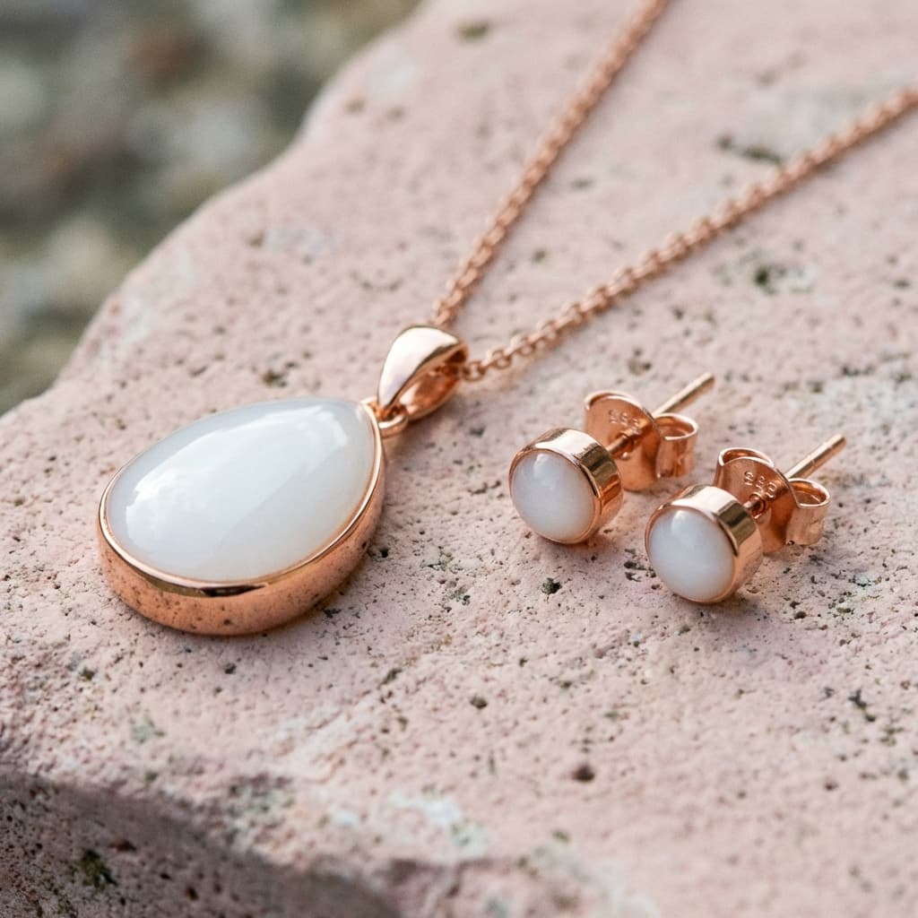 Rose gold necklace pendant and matching stud earrings with milky white resin stones, made with a breastmilk jewelry diy kit for a personalized keepsake